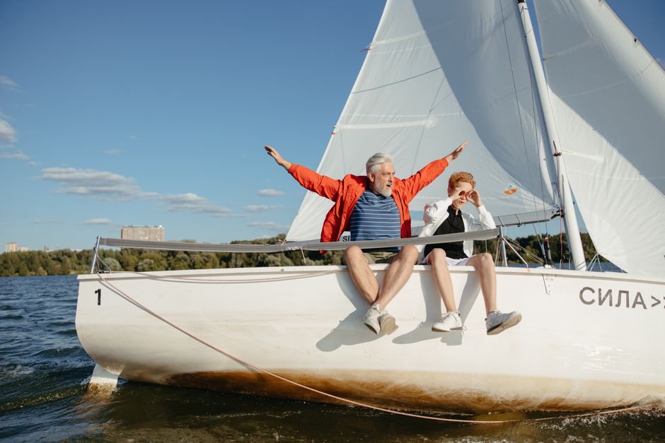 A joyful day on the water with a grandfather and grandson sailing on a sunny summer day.